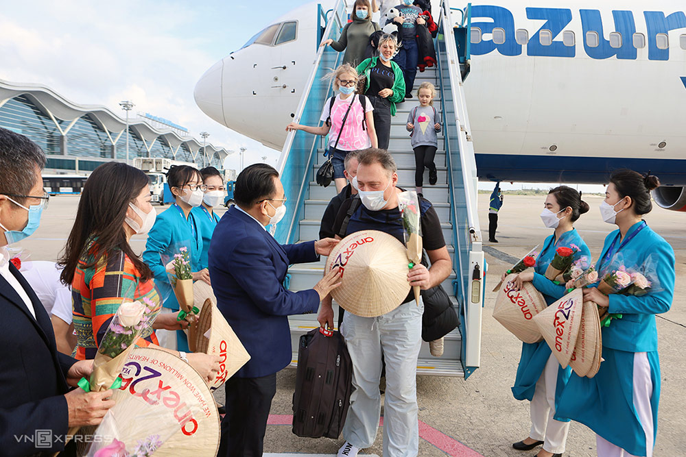 Phó chủ tịch UBND Khánh Hòa ông Lê Hữu Hoàng (áo vest bên trái) tặng quà cho khách Nga đến Cam Ranh đón năm mới 2022. Ảnh: Xuân Ngọc